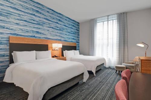 a hotel room with two beds and a mural at TownePlace Suites by Marriott Cincinnati Downtown in Cincinnati