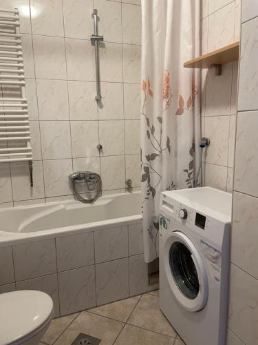 La salle de bains est pourvue d'une baignoire et d'un lave-linge. dans l'établissement Apartments Vip, à Split