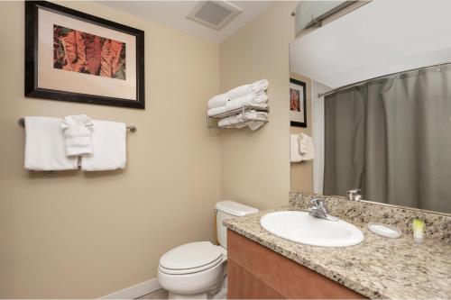 a bathroom with a sink and a toilet and a mirror at Fraser Crossing Unit 3618 in Winter Park