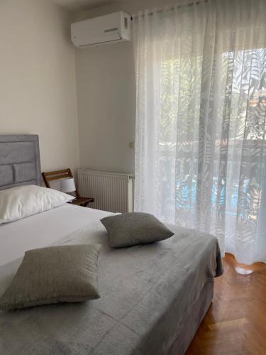 a bedroom with a bed with two pillows and a window at Apartments Vip in Split