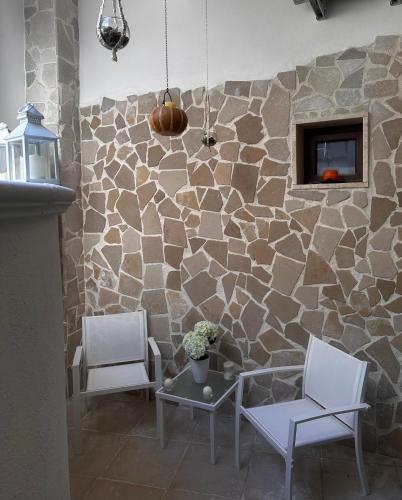 a room with two chairs and a stone wall at Eterea Casa Vacanza in Brindisi