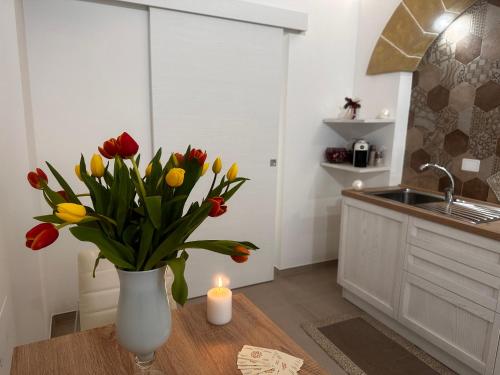 a vase of tulips on a table in a kitchen at Eterea Casa Vacanza in Brindisi