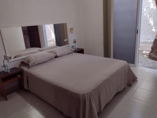 uma cama num quarto com uma grande janela em Las Margaritas Casa de Huéspedes em Cancún