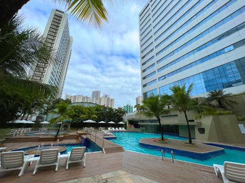 a swimming pool with chairs and a building at Mar Hotel Conventions in Recife