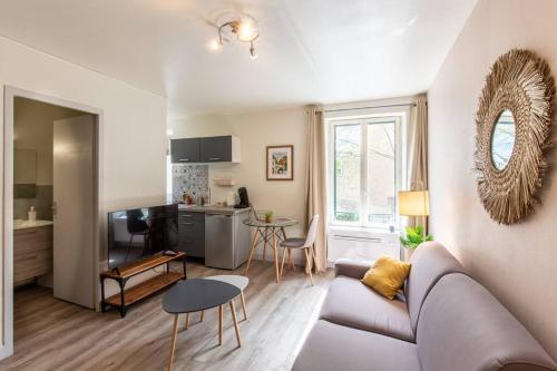 un salon avec un canapé et une cuisine dans l'établissement Le Magenta, Studio proche de la place Wilson, à Dijon