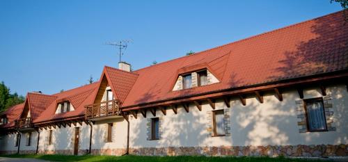 un bâtiment avec un toit rouge dans l'établissement Sokoli Dwór, à Smardzewice