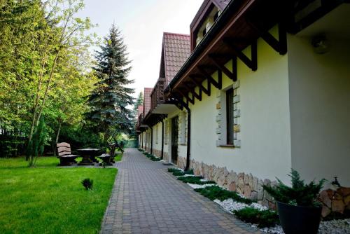 une passerelle en briques à côté d'un bâtiment avec un arbre dans l'établissement Sokoli Dwór, à Smardzewice