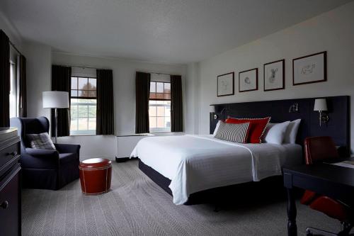 een slaapkamer met een groot wit bed en een stoel bij College Park Marriott Hotel & Conference Center in College Park