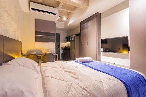 a bedroom with a large bed and a television at TOLIVE One Housi Recife by Carpediem in Recife