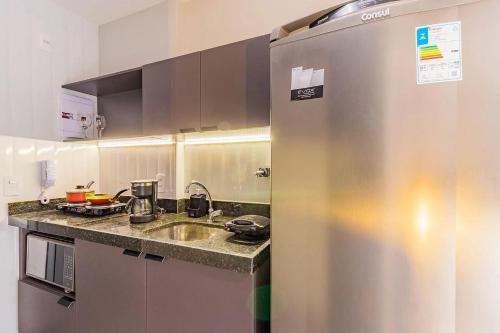 a kitchen with a stainless steel refrigerator next to a sink at TOLIVE One Housi Recife by Carpediem in Recife