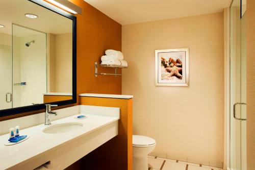 a bathroom with a sink and a toilet and a mirror at Fairfield Inn & Suites by Marriott Tustin Orange County in Tustin