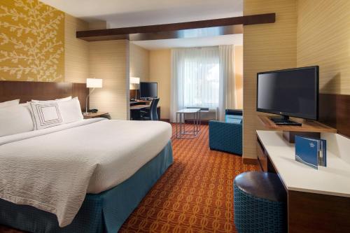 a hotel room with a bed and a flat screen tv at Fairfield Inn & Suites by Marriott Tustin Orange County in Tustin