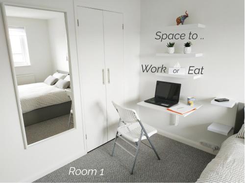 a bedroom with a desk with a laptop and a mirror at Town House Chantry - With Self Check In and Free Parking - Rooms at ipswichdigs in Ipswich