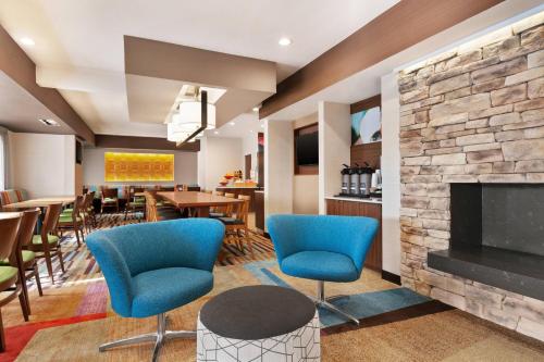 a lobby with blue chairs and a fireplace at Fairfield Inn Roseville in Roseville