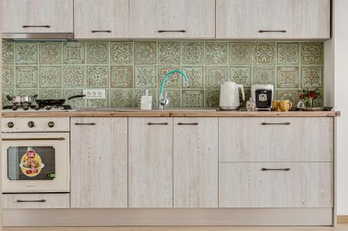 a kitchen with wooden cabinets and a sink and a stove at ARI Central Apartment 2 in Arad