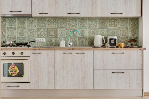 a kitchen with wooden cabinets and a sink and a stove at Ultra Central Apartment with Private Terrace in Arad