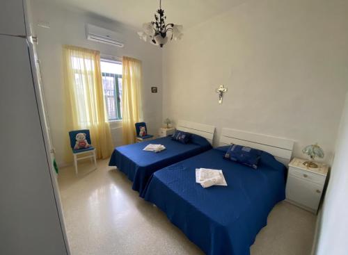 バレッタにあるValletta 3 Bedroom Apartmentのベッドルーム1室(青いシーツが備わるベッド2台付)