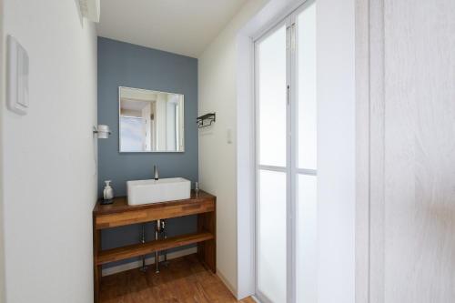 y baño con lavabo blanco y espejo. en Rush Awaji Guppy - Seaside Holiday Home - Self Check-In Only, en Awaji