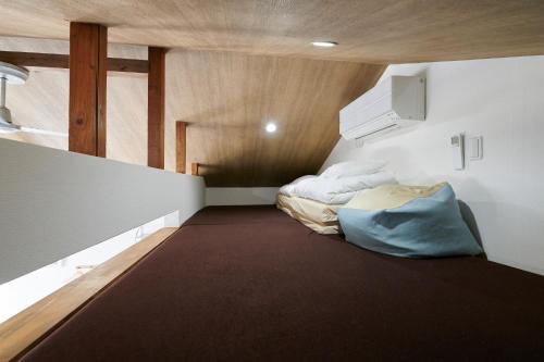 a small room with a bed in the corner at Rush Awaji Guppy - Seaside Holiday Home - Self Check-In Only in Awaji