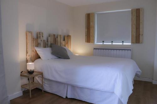 a bedroom with a white bed with a laptop on it at The Hen House in Bere Alston