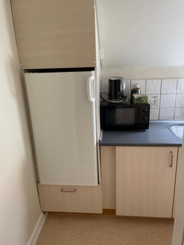 a small kitchen with a microwave and a sink at Cafe Sallys bed and breakfast in Ribe