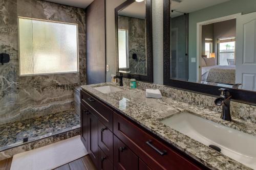 ein Badezimmer mit einer Badewanne, einem Waschbecken und einem Spiegel in der Unterkunft Gilbert Home with Pool, Near Golfing and Downtown! in Gilbert