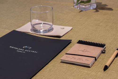 a table with a glass and a notebook and a pen at Hotel Club La Serena in La Serena