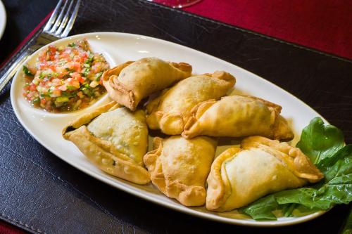 a plate of food with wontons and rice on a table at Hotel Club La Serena in La Serena