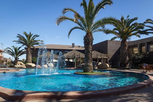 a large fountain with palm trees in a courtyard at Hotel Club La Serena in La Serena