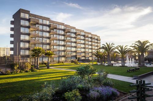 a large building with a park in front of it at Hotel Club La Serena in La Serena