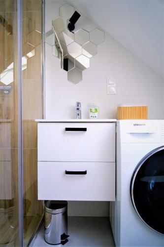 a white bathroom with a sink and a shower at Siedlisko Czerniówka in Paprotnia