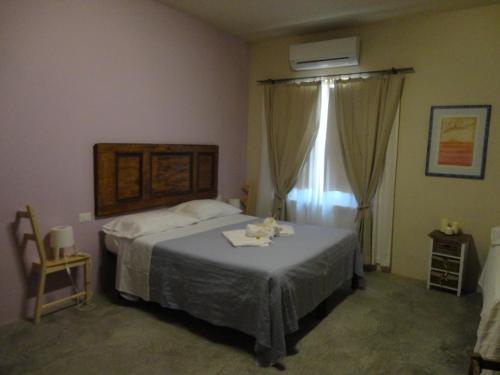 1 dormitorio con cama y ventana en Il Glicine 3, en San Gimignano