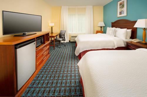 a hotel room with two beds and a flat screen tv at Fairfield Inn & Suites by Marriott Marshall in Marshall