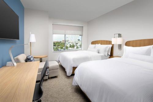 Habitación de hotel con 2 camas y TV de pantalla plana. en Element Orlando Universal Blvd. en Orlando