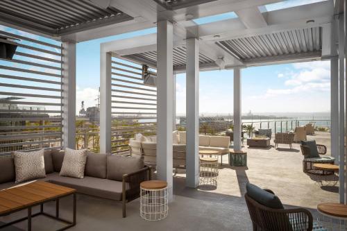 a patio with a couch and tables on a balcony at SpringHill Suites by Marriott San Diego Downtown/Bayfront in San Diego