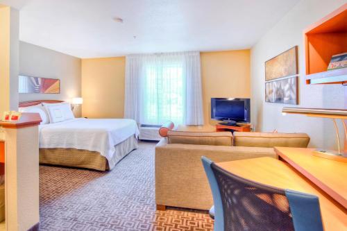 Habitación de hotel con cama y TV en TownePlace Suites Raleigh Cary/Weston Parkway, en Cary