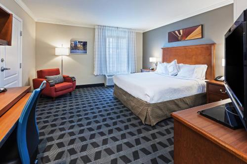 オデッサにあるTownePlace Suites by Marriott Odessaのベッドとテレビが備わるホテルルームです。