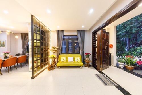 a living room with a yellow chair and a table at Villa Đà Lạt Khởi Nghĩa Bắc Sơn Gần Hồ Xuân Hương Gần Chợ Đêm - KNBS Lana in Xuan An