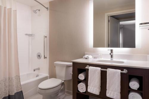 a bathroom with a toilet and a sink and a mirror at Residence Inn by Marriott Santa Barbara Goleta in Santa Barbara