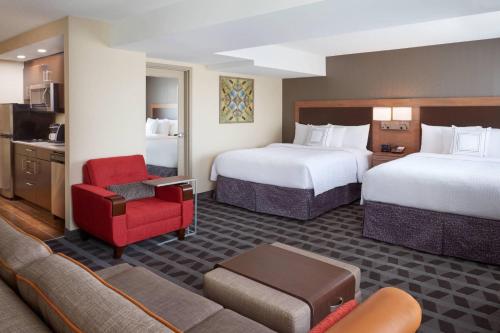 a hotel room with two beds and a couch at TownePlace Suites by Marriott Windsor in Windsor