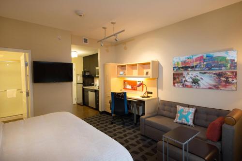 a hotel room with a bed and a couch and a desk at TownePlace Suites by Marriott Lincoln North in Lincoln