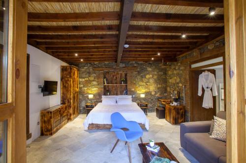 sypialnia z łóżkiem i niebieskim krzesłem w obiekcie Lyhnos w mieście Askas