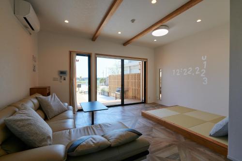 ein Wohnzimmer mit einem Sofa und einem Tisch in der Unterkunft Rush Awaji - Seaside Holiday Home - Self Check-In Only in Awaji