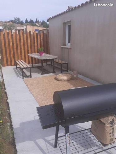 a backyard with a picnic table and a bench at Agréable petite maison in Vagnas