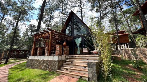 a small building with a staircase in the grass at Chalets Villa Maria in Huasca de Ocampo