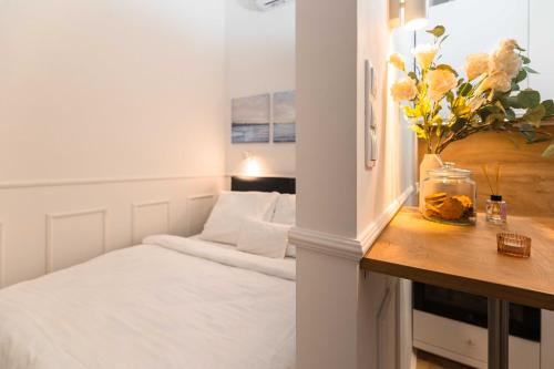 um pequeno quarto com uma cama e uma mesa com flores em Charming studio - in the downtown em Budapeste