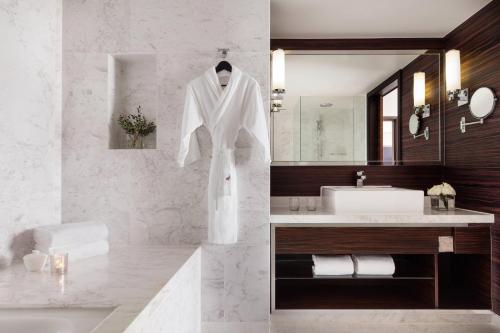 a bathroom with a white robe hanging on a wall at Hong Kong SkyCity Marriott Hotel in Hong Kong