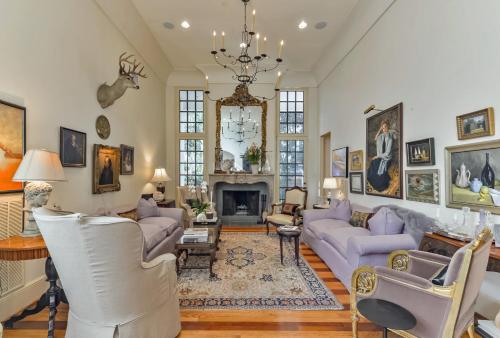 a living room with purple couches and a fireplace at Elegant French Patio Home with Private Pool in Houston