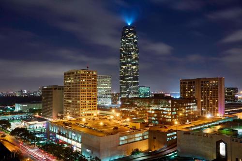 JW Marriott Houston by the Galleria في هيوستن: أفق المدينة في الليل مع مبنى طويل