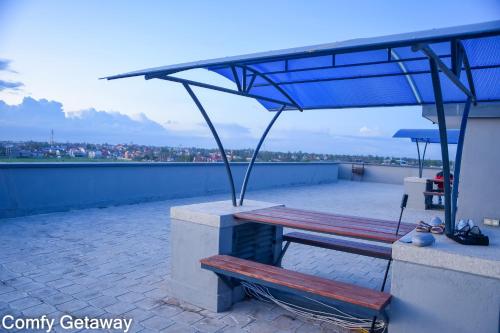 a couple of benches sitting on top of a roof at Comfy Getaway STUDIO apartment near JKIA & SGR with KING BED, WIFI, NETFLIX and SECURE PARKING in Syokimau